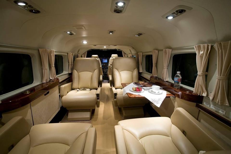 King Air executive cabin with cream leather seating and polished wood tables prepared for a corporate charter