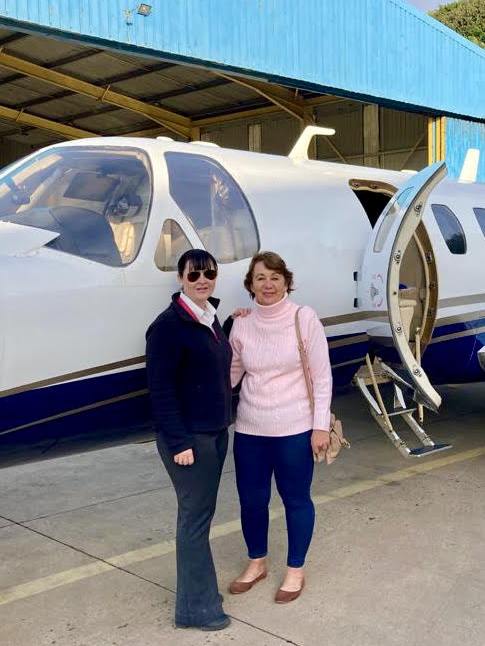 Aviation ONE crew member with a client beside a Cessna Citation business jet in the hangar