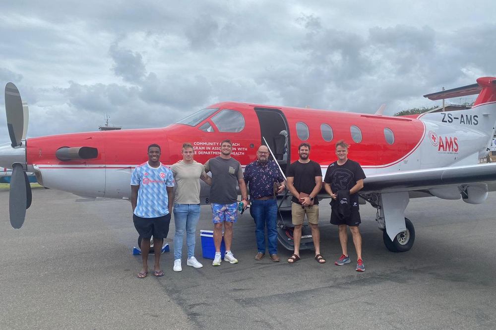 Aviation ONE crew beside a Pilatus PC-12 in air mercy service livery before a humanitarian relief flight