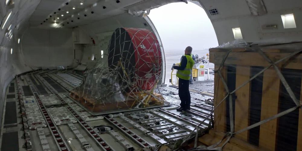 Outsize industrial component secured in cargo netting on the main deck of a freighter aircraft during loading