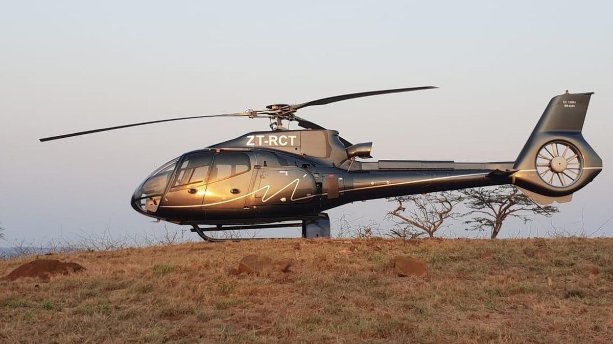 Airbus H130 helicopter shut down on an open hilltop at last light after a private charter flight