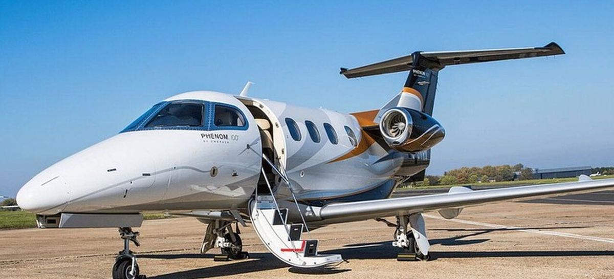 Embraer Phenom 100 light jet parked on the ramp with airstairs down, fully serviced and ready