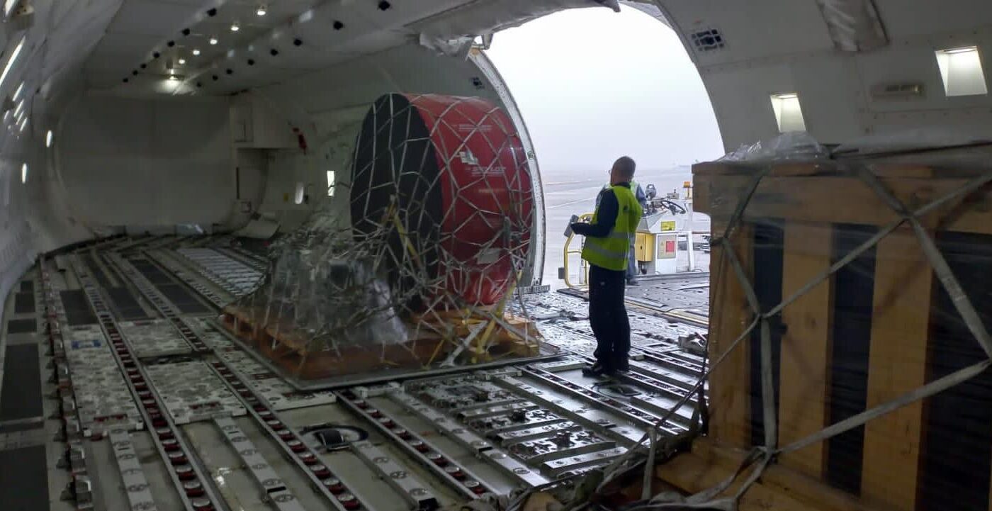 Outsize industrial component secured in cargo netting on the main deck of a freighter aircraft during loading