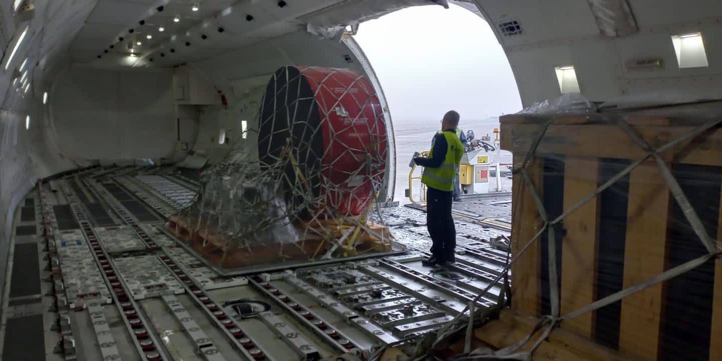 Outsize industrial component secured in cargo netting on the main deck of a freighter aircraft during loading