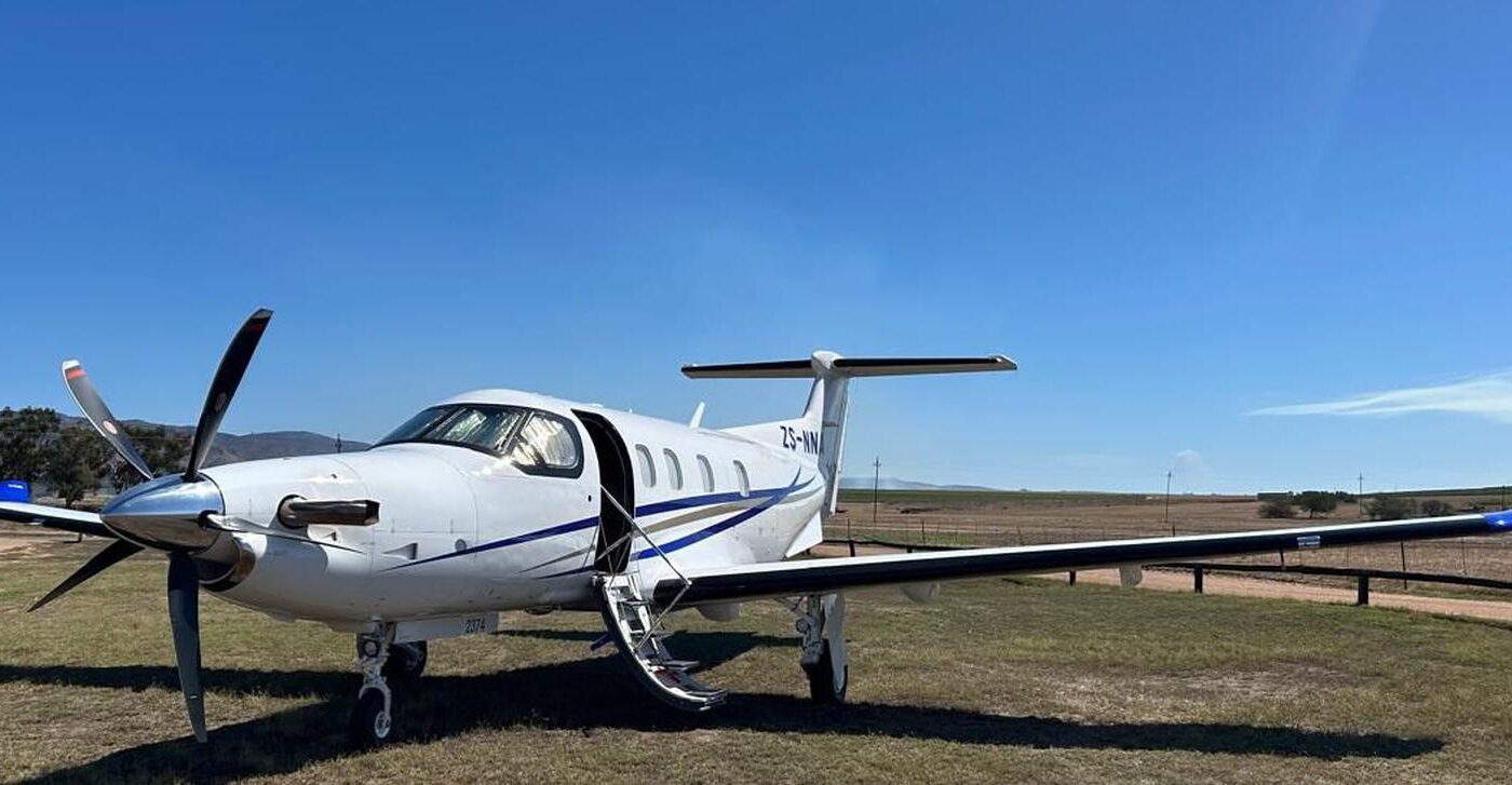 Pilatus PC-12 executive turboprop parked on a grass airstrip in the Western Cape before a corporate charter
